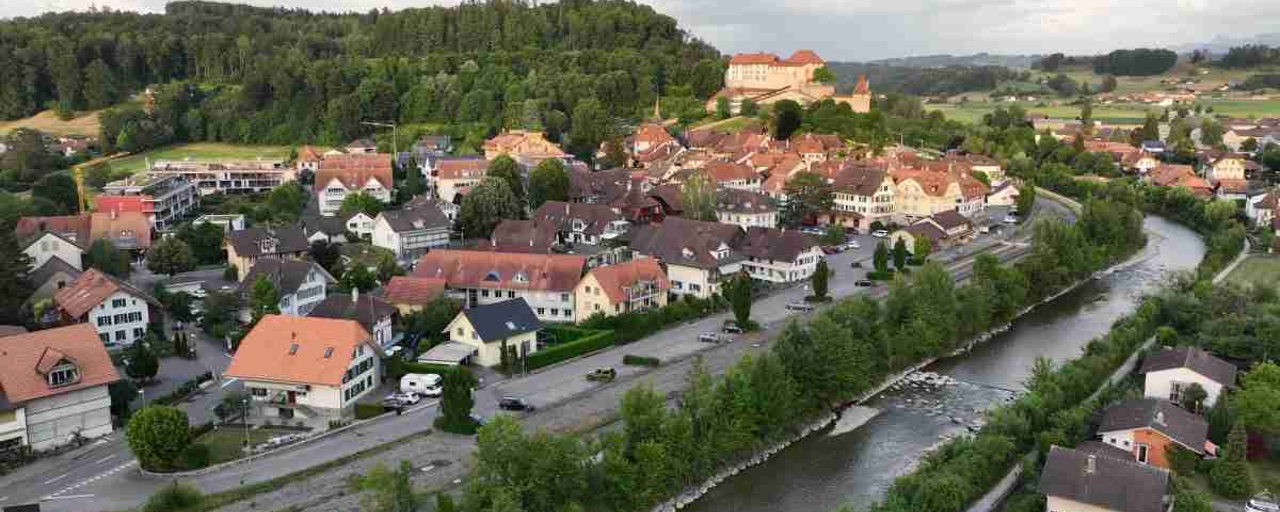 Luftaufnahme von Laupen mit Stedtli und Schloss im Hintergrund